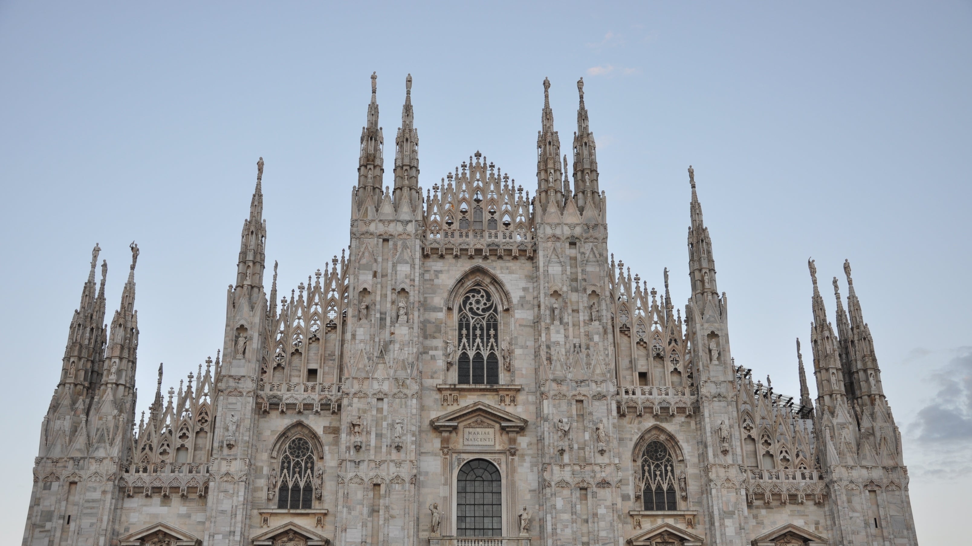 Duomo di Milano, a Gothic cathedral with multiple spires against a clear sky in Milan, Italy.